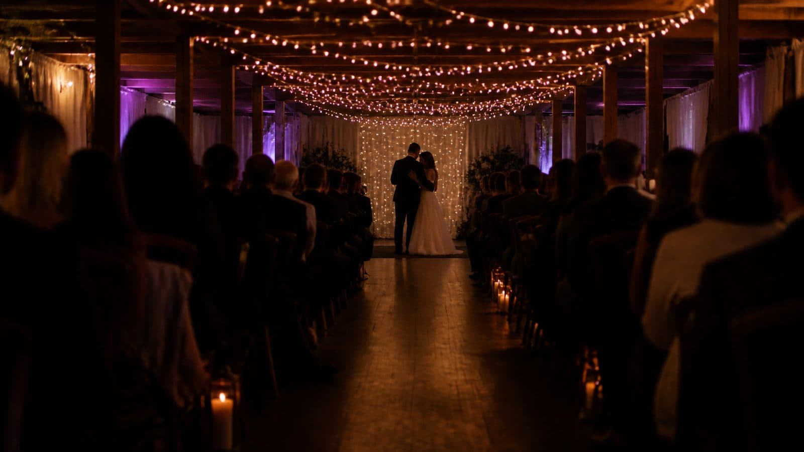 A couple's first dance seen from the back of a candlelit wedding reception